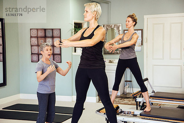 Frauen im Fitnessstudio mit Pilates-Reformer