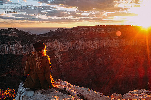 Frau sitzt am Rand des Grand Canyon  Arizona  USA