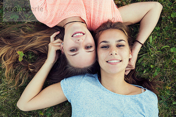Portrait von zwei jungen Frauen  die im Gras liegen