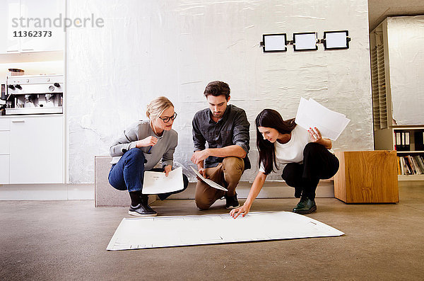 Architekten im Büro diskutieren über Entwürfe