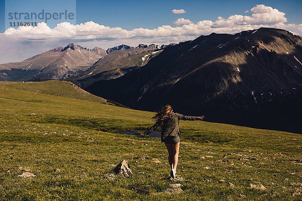 Frau balanciert auf Fels und Bergen  Rocky Mountain National Park  Colorado  USA