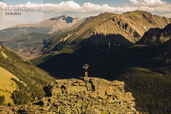 Rückansicht einer Frau auf einem Felsvorsprung mit Blick in die Ferne  Rocky Mountain National Park  Colorado  USA