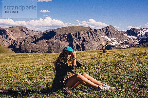 Frau sitzt im Feld mit Elch  Rocky Mountain National Park  Colorado  USA