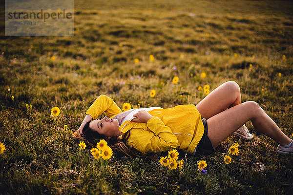 Frau liegt auf Gras in blumenreicher Wiese  Rocky Mountain National Park  Colorado  USA