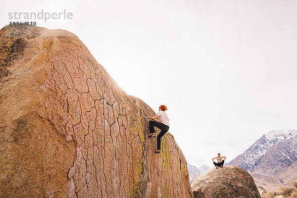 Freunde klettern auf Felsen  Buttermilk Boulders  Bishop  Kalifornien  USA