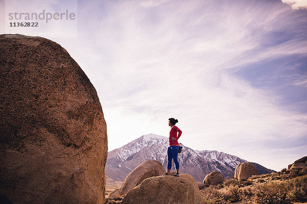 Frau steht auf der Spitze eines Felsens und schaut weg  Buttermilk Boulders  Bishop  Kalifornien  USA