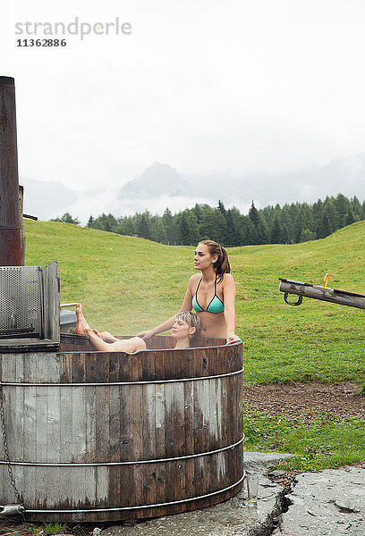 Zwei Freundinnen entspannen sich im ländlichen Whirlpool  Sattelbergalm  Tirol  Österreich