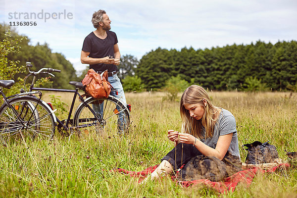 Paar mit Fahrrädern beim Picknick auf dem Land