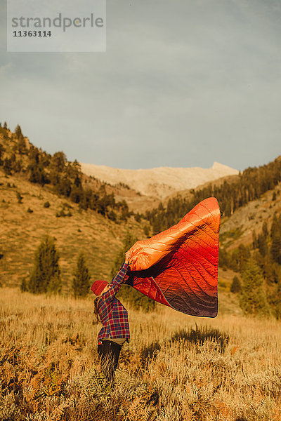 Schwangere Frau steht im Feld  schüttelt Schlafsack aus  Mineral King  Sequoia National Park  Kalifornien  USA