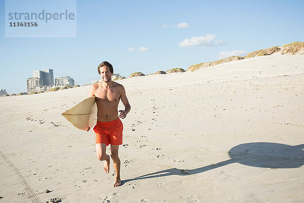 Junge männliche Surfer laufen am Strand  Kapstadt  Western Cape  Südafrika