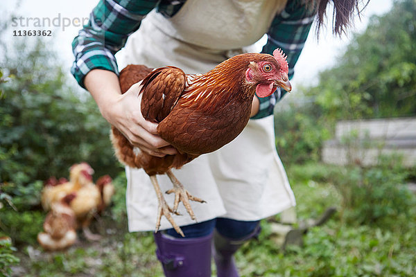 Frau auf Hühnerfarm mit Hühnern