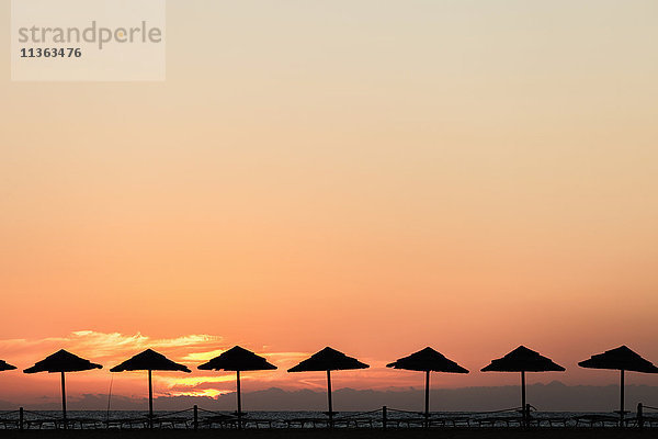 Silhouette eines Sonnenschirms bei Sonnenuntergang  Piscinas  Sardinien  Italien