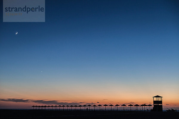 Silhouette von Sonnenschirmen bei Sonnenuntergang  Piscinas  Sardinien  Italien