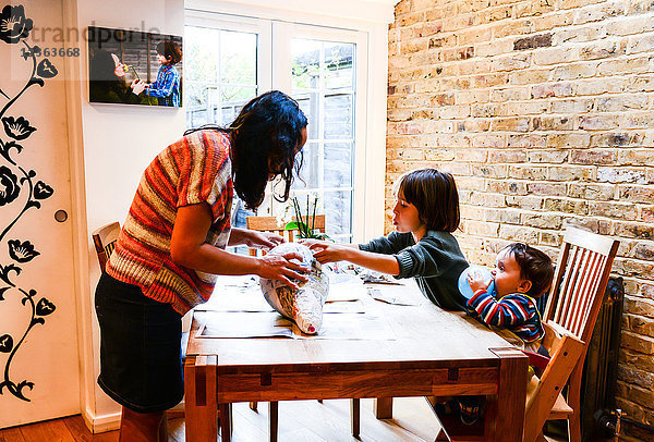 Kind und Mutter spielen mit Pappmaché