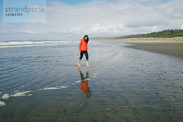 Junge Frau läuft barfuss am Strand  Long Beach  Vancouver Island  Britisch-Kolumbien  Kanada