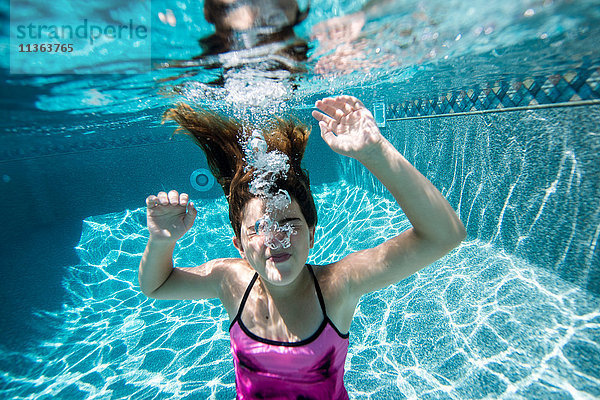 Mädchen bläst Blasen im Schwimmbad
