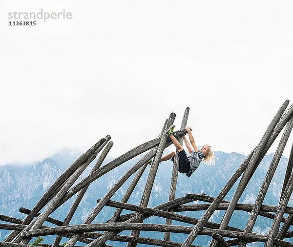 Junge klettert an Holzkonstruktion auf Spielplatz  Füssen  Bayern  Deutschland