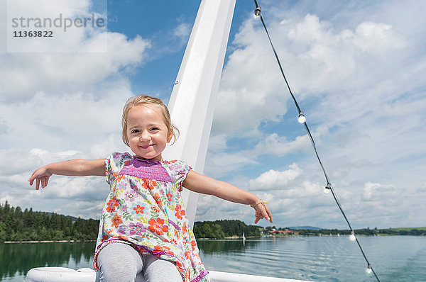 Porträt eines Mädchens auf einem Boot  das lächelnd in die Kamera schaut  Füssen  Bayern  Deutschland
