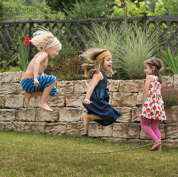 Kinder spielen mit Springseilspringen in der Luft