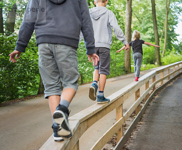 Rückansicht von Jungen  die auf einem Handlauf balancieren