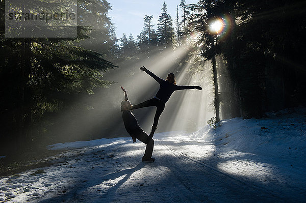 Silhouetten von Akrobaten beim Balancieren im schneebedeckten Wald  Froschteich  Mount Hood  Oregon  USA