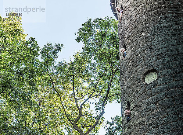 Jungen  die sich aus steinernen Turmfenstern lehnen