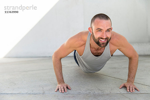 Männertraining für mittlere Erwachsene  die auf der Terrasse Liegestützen machen