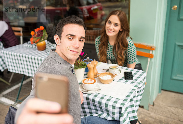 Pärchen im Straßencafé beim Selbstgespräch