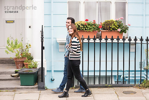 Seitenansicht des Paares  das lächelnd auf der Straße geht
