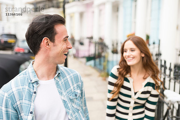 Paar in der Straße von Angesicht zu Angesicht lächelnd