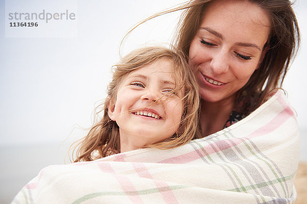 Glückliche Mutter und Tochter in eine Decke gehüllt