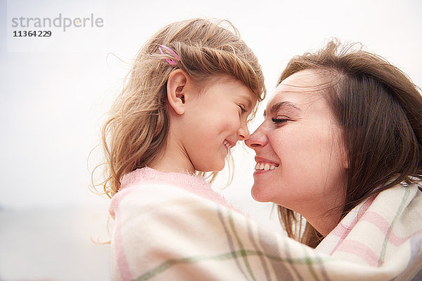 Glückliche Mutter und Tochter in eine Decke gehüllt  Nasen reiben
