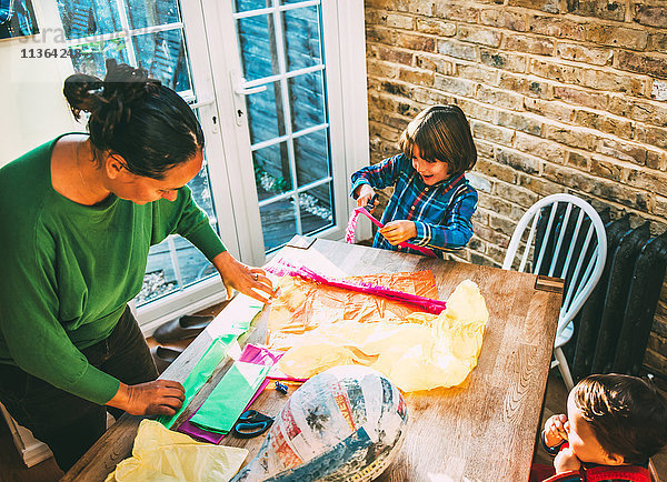 Mutter und Sohn schmücken Pinata zu Hause