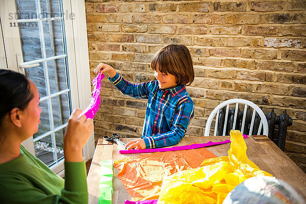 Mutter und Sohn spielen zu Hause mit pinata