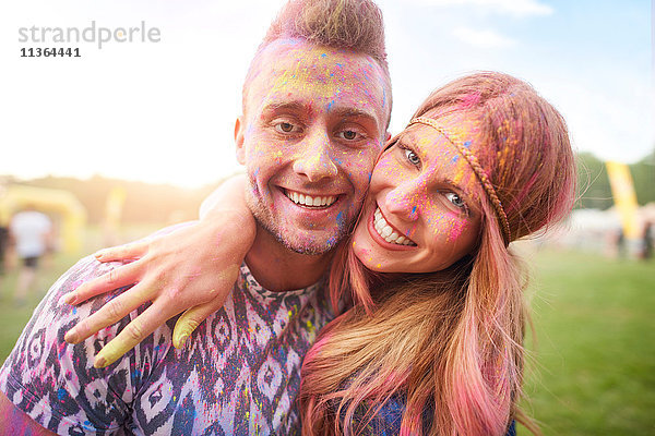 Zwei Freunde auf dem Fest  bedeckt mit bunter Pulverfarbe