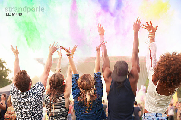Gruppe von Freunden beim Festival  die bunte Pulverfarbe in die Luft werfen  Rückansicht