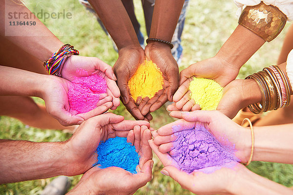 Gruppe von Freunden beim Festival  die bunte Pulverfarbe in schalenförmigen Händen halten  Nahaufnahme