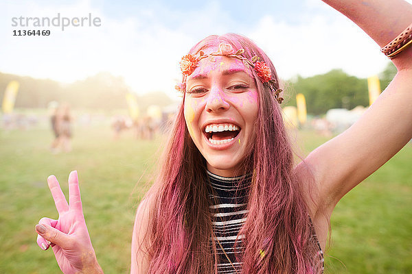 Porträt einer jungen Frau beim Festival  bedeckt mit bunter Pulverfarbe