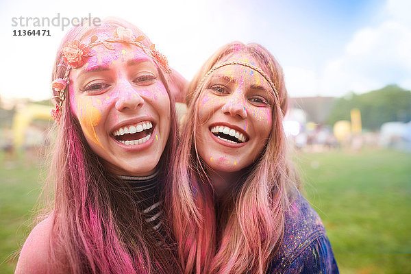 Porträt von zwei Freundinnen beim Festival  mit bunter Pulverfarbe überzogen