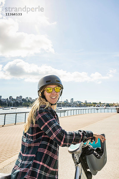 Porträt einer Frau auf dem Fahrrad am Wasser  Vancouver  Kanada