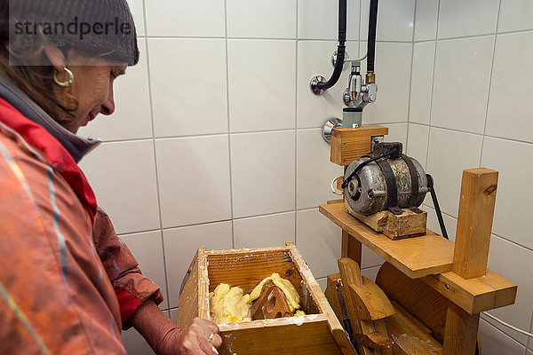 Ältere Milchbäuerin beim Buttern in der Milchbauernküche  Sattelbergalm  Tirol  Österreich