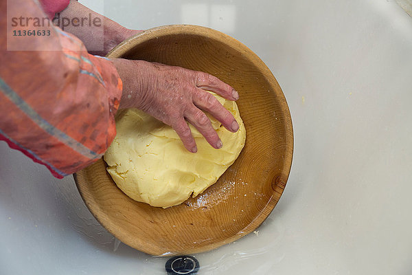 Hände einer Milchbäuerin  die Butter in einer Schüssel formt  Sattelbergalm  Tirol  Österreich