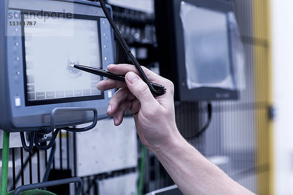 Ingenieur in einer technischen Anlage  mit dem Stift auf dem Bildschirm  Nahaufnahme