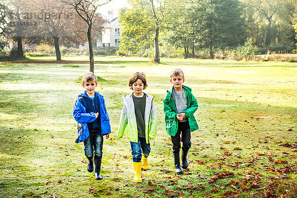 Drei Jungen  im Freien  gehen über das Feld