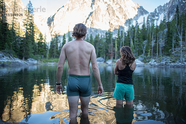 Junger Mann und Frau stehen im See  Rückansicht  Die Verzauberungen  Alpine Lakes Wilderness  Washington  USA