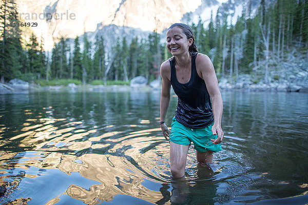 Junge Frau watet durch den See  The Enchantments  Alpine Lakes Wilderness  Washington  USA