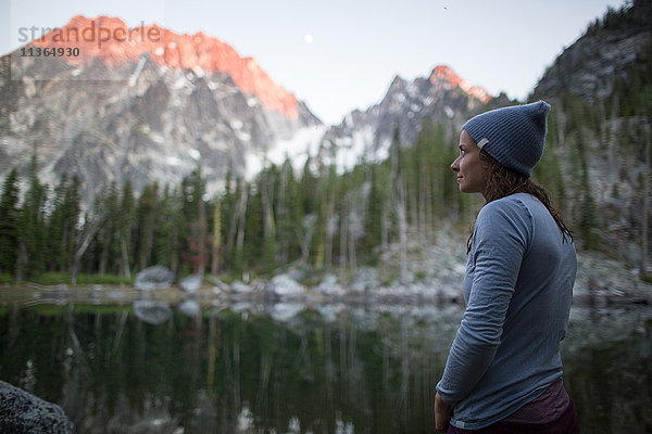 Junge Frau steht am See und schaut auf die Aussicht  Die Verzauberungen  Alpine Lakes Wilderness  Washington  USA