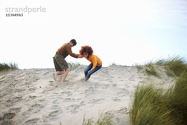 Paar spielt auf der Spitze einer Sanddüne