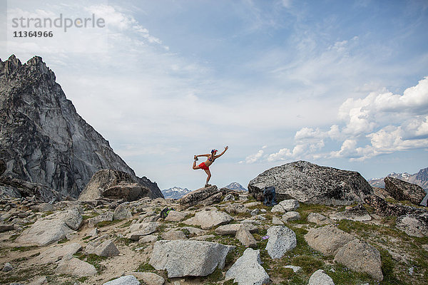Junge Frau auf Felsen stehend  in Yoga-Pose  Die Verzauberungen  Alpine Lakes Wilderness  Washington  USA