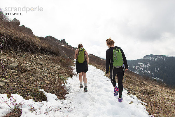 Zwei junge Frauen wandern am Berghang entlang  Rückansicht  Silver Star Mountain  Washington  USA